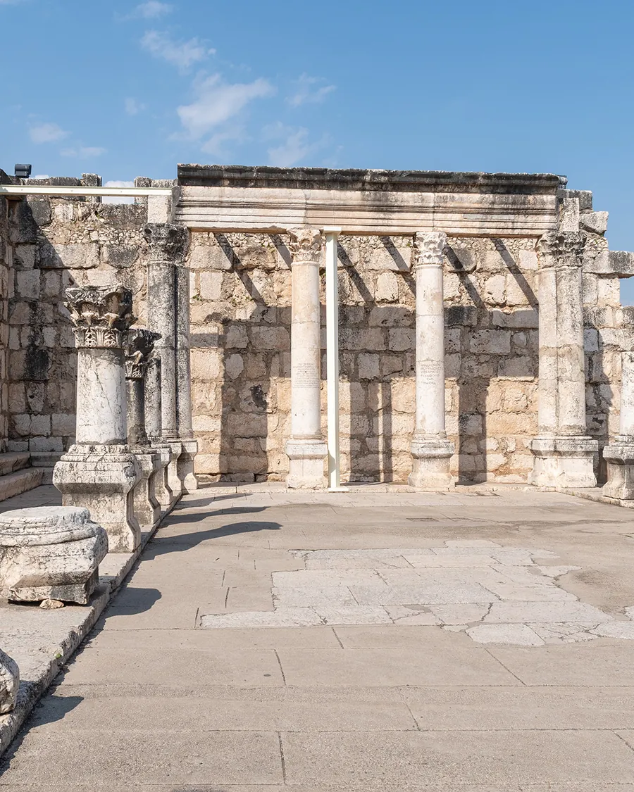 Kolumny i mury z białego wapienia w ruinach synagogi w Kafarnaum