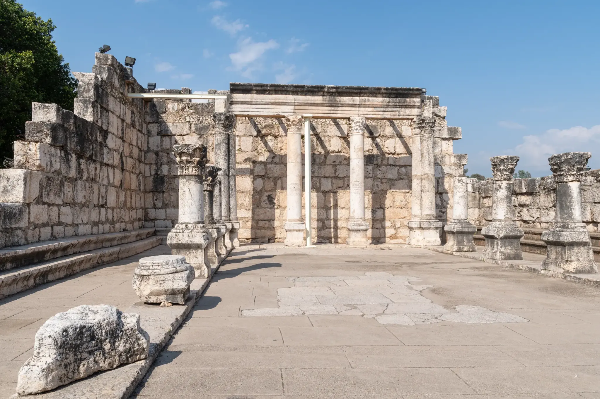 Kolumny i mury z białego wapienia w ruinach synagogi w Kafarnaum